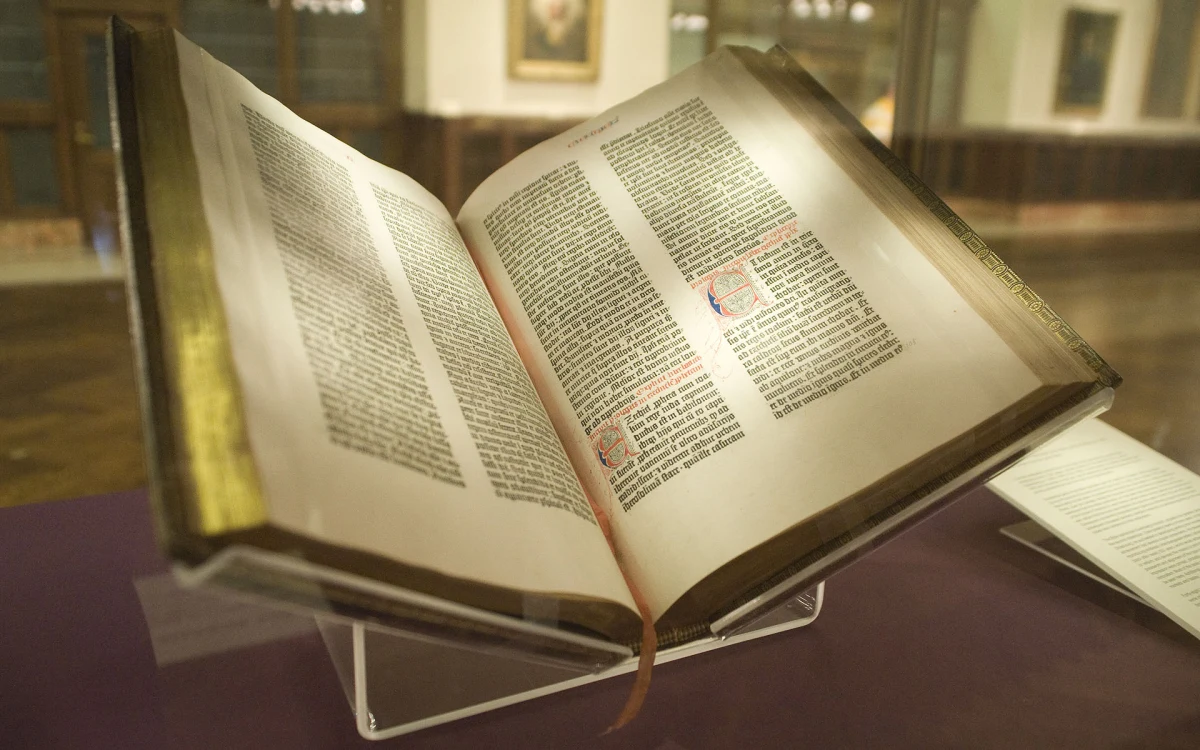 Bibliothèque ouverte avec une Bible, lumière naturelle, atmosphère studieuse et sobre.